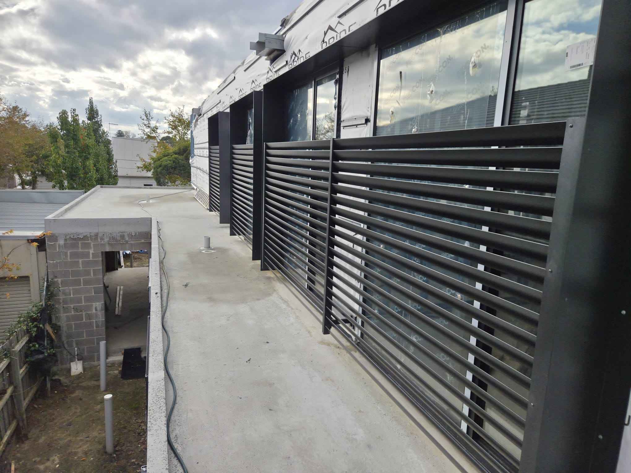 Horizontal aluminium slat screening along a townhouse walkway