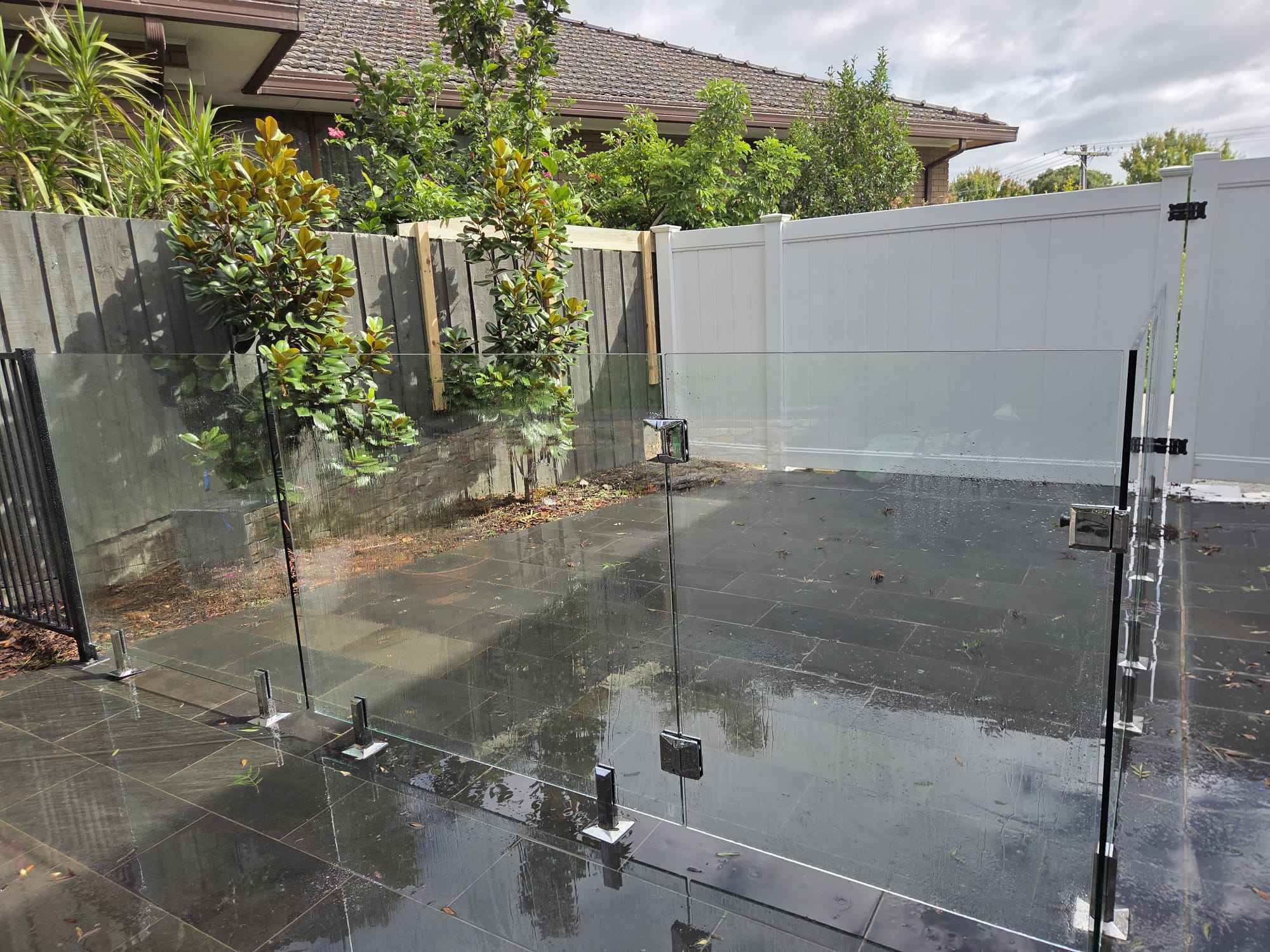 Frameless glass pool fencing with stainless spigots